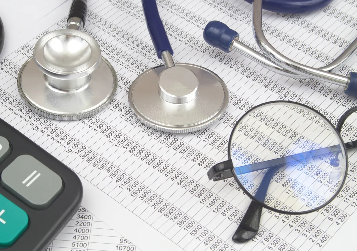 A stethoscope on top of a medical bill reflecting the high cost of medical care after a car accident