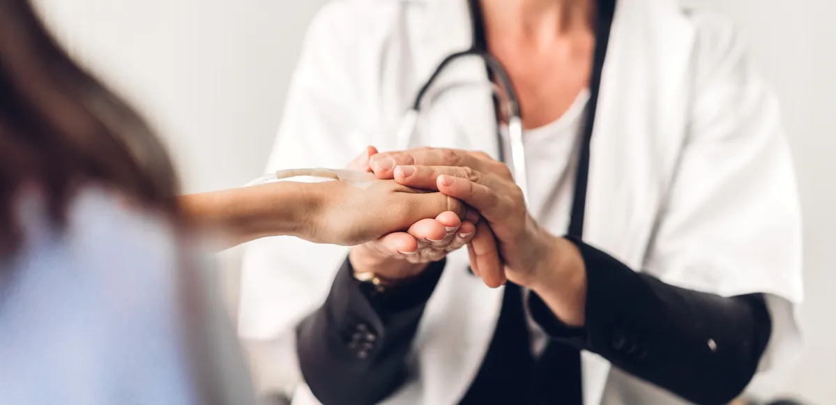 Image of a doctor holding a women's hand after a car accident