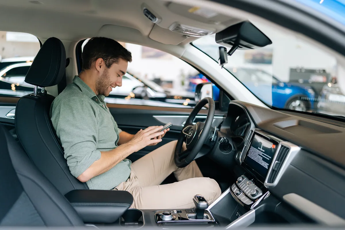 Image of a man texting on his phone while driving to represent Nevada texting and cell phone laws