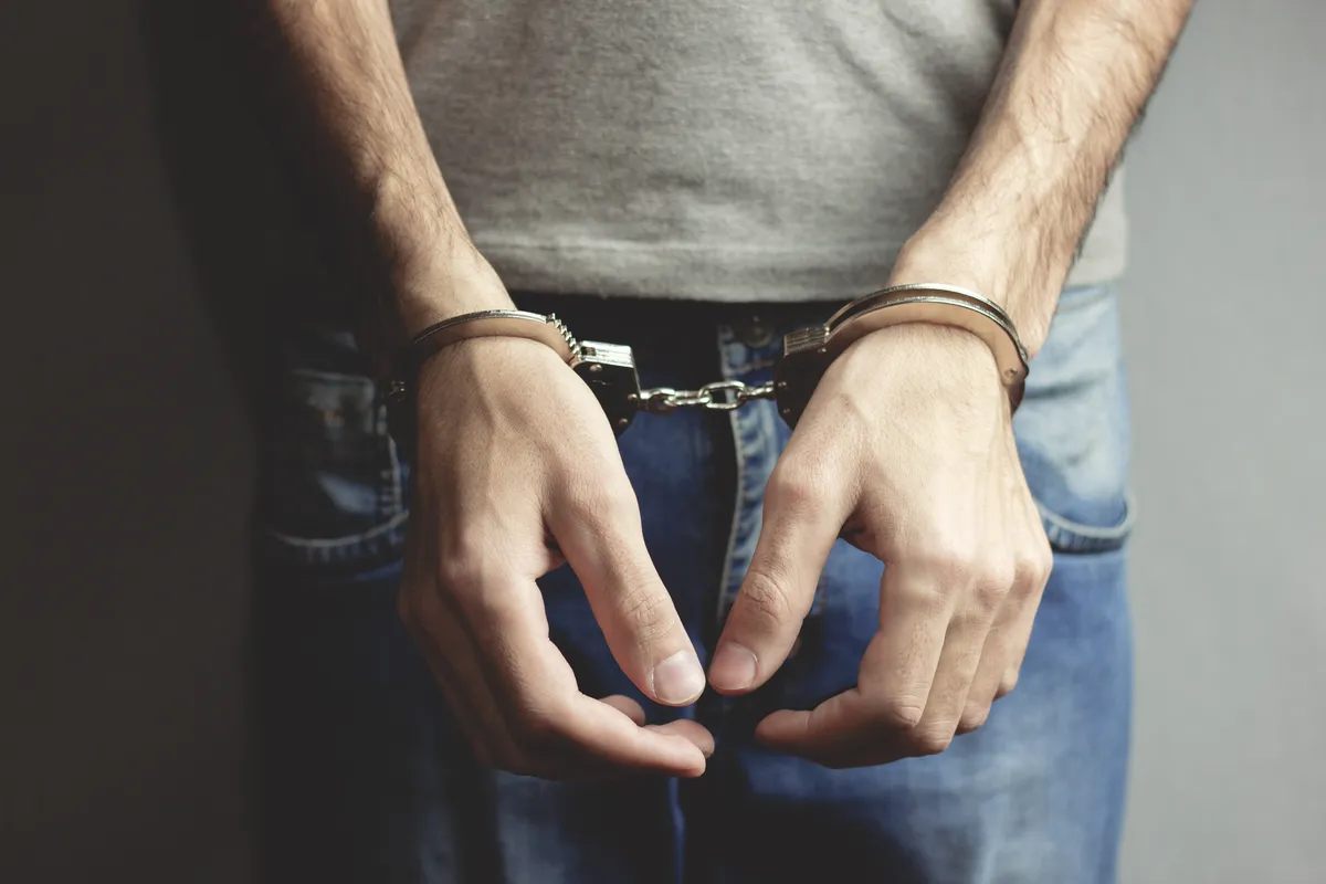 Image of a man wearing handcuffs used to represent the jail time that can result from a hit-and-run in Nevada