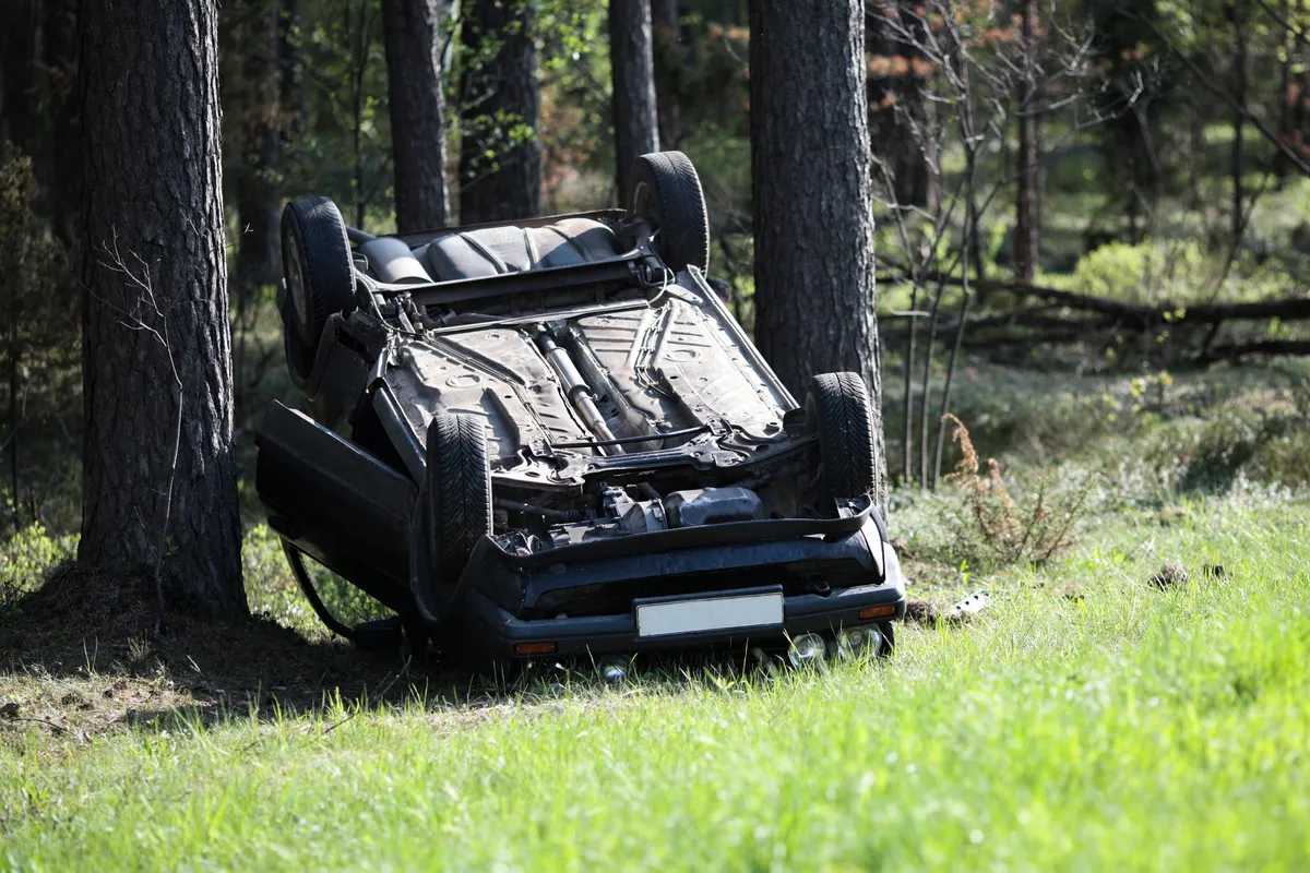  a car that has been flipped over in the woods