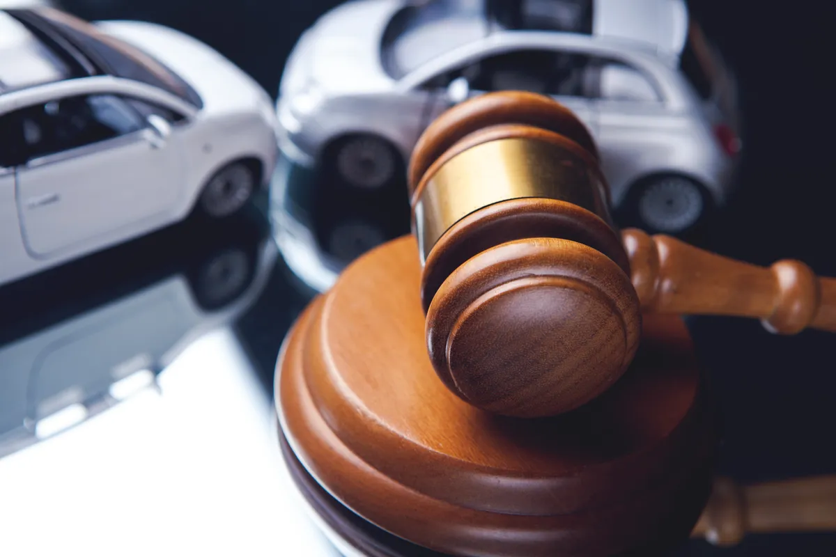 a close up of a gavel on a table with a toy car in the background