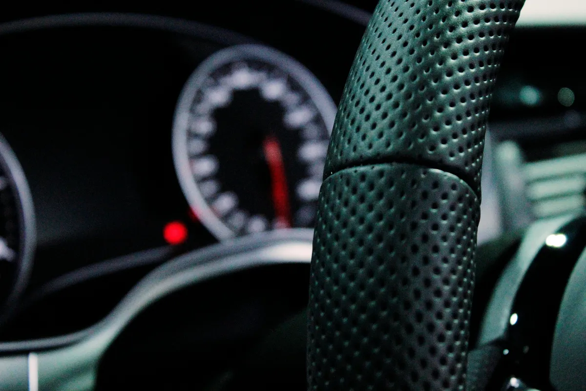 a close up of a steering wheel with a speedometer and gauge