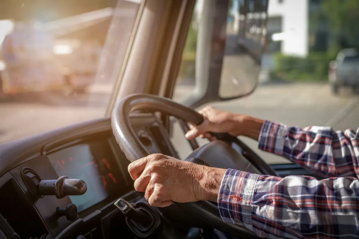  a man driving a truck on the street