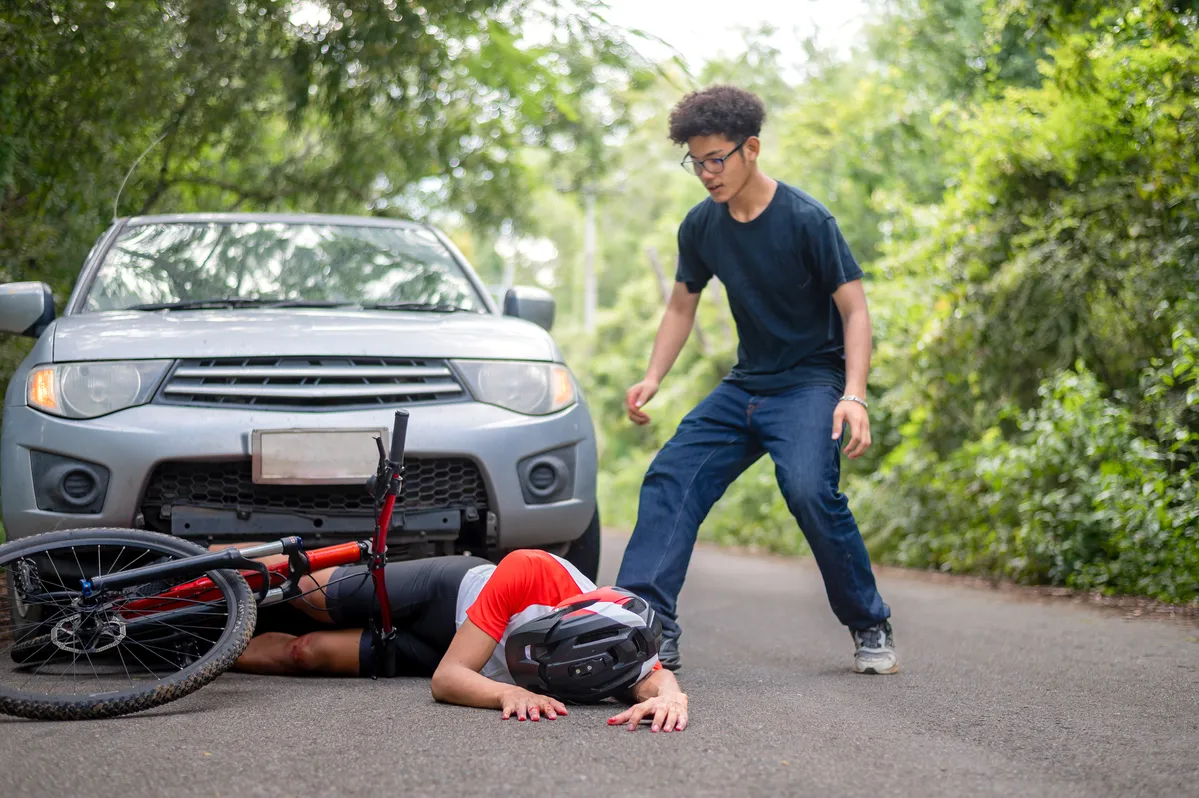  a man standing next to a car with a bike on the ground