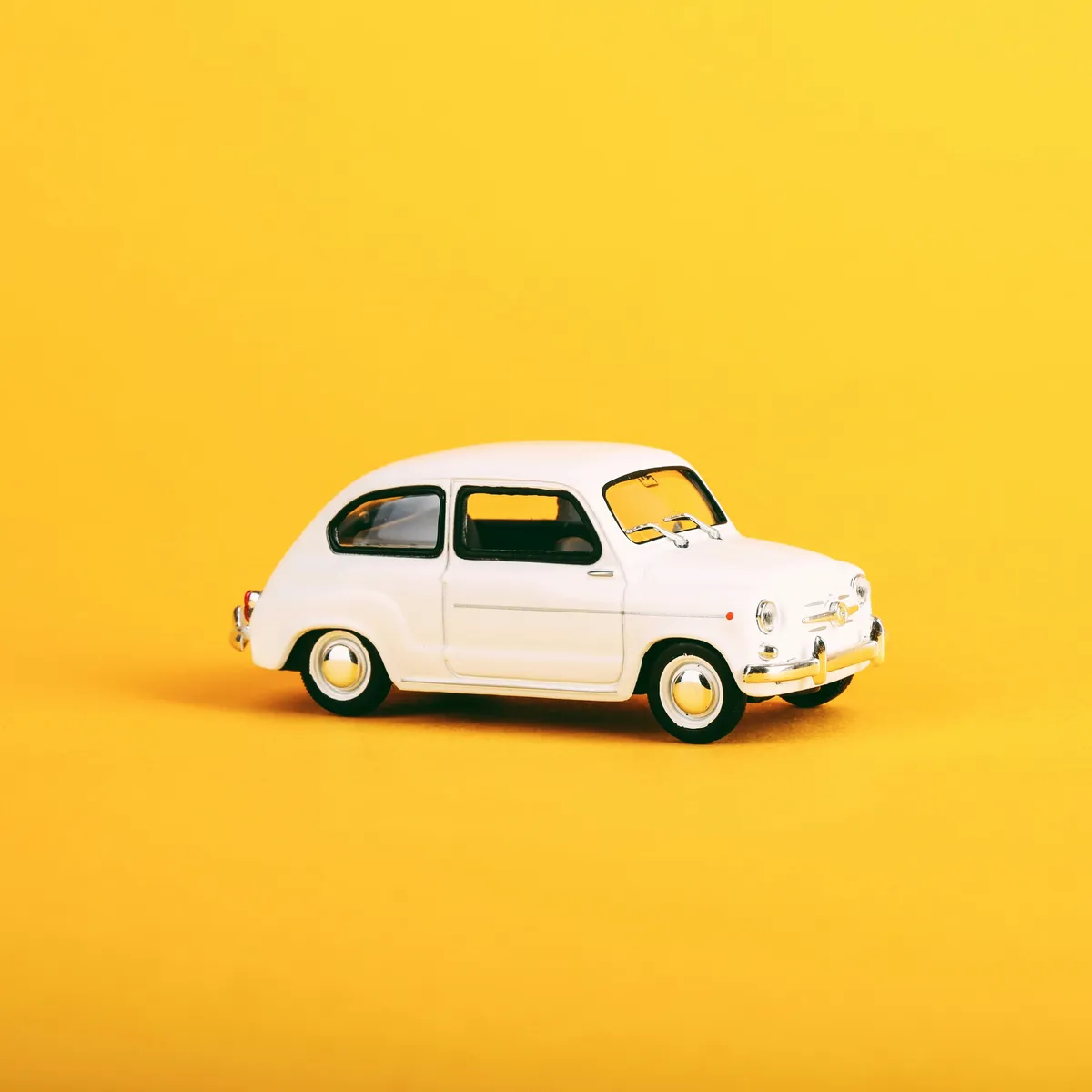  a small toy car that is sitting on a yellow surface