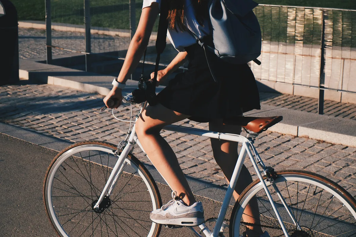  a woman riding a bike with a backpack on the back