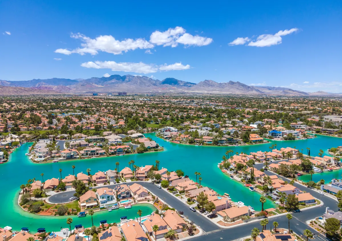 aerial view of a residential area with a lake and mountains in the background