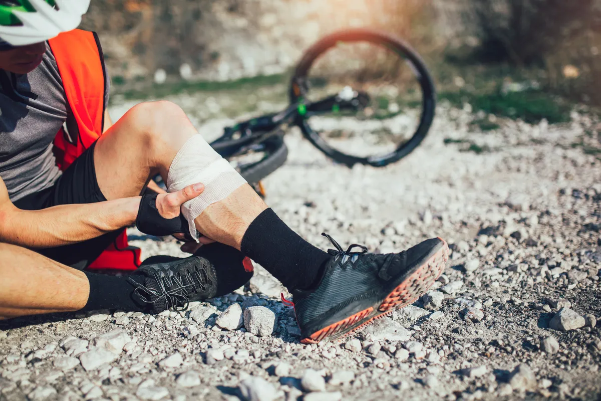 arafed man sitting on the ground with his knee bandaged