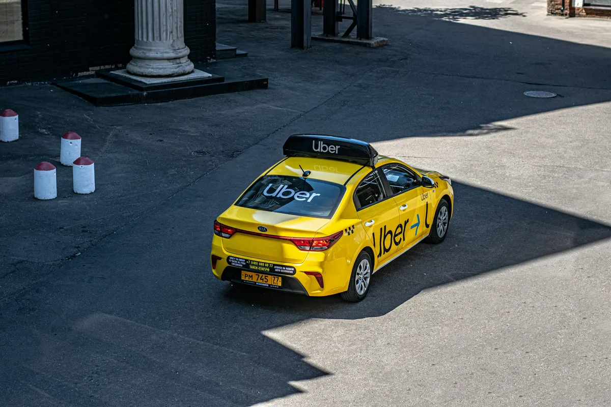 arafed taxi cab with a sign on the roof parked in a parking lot