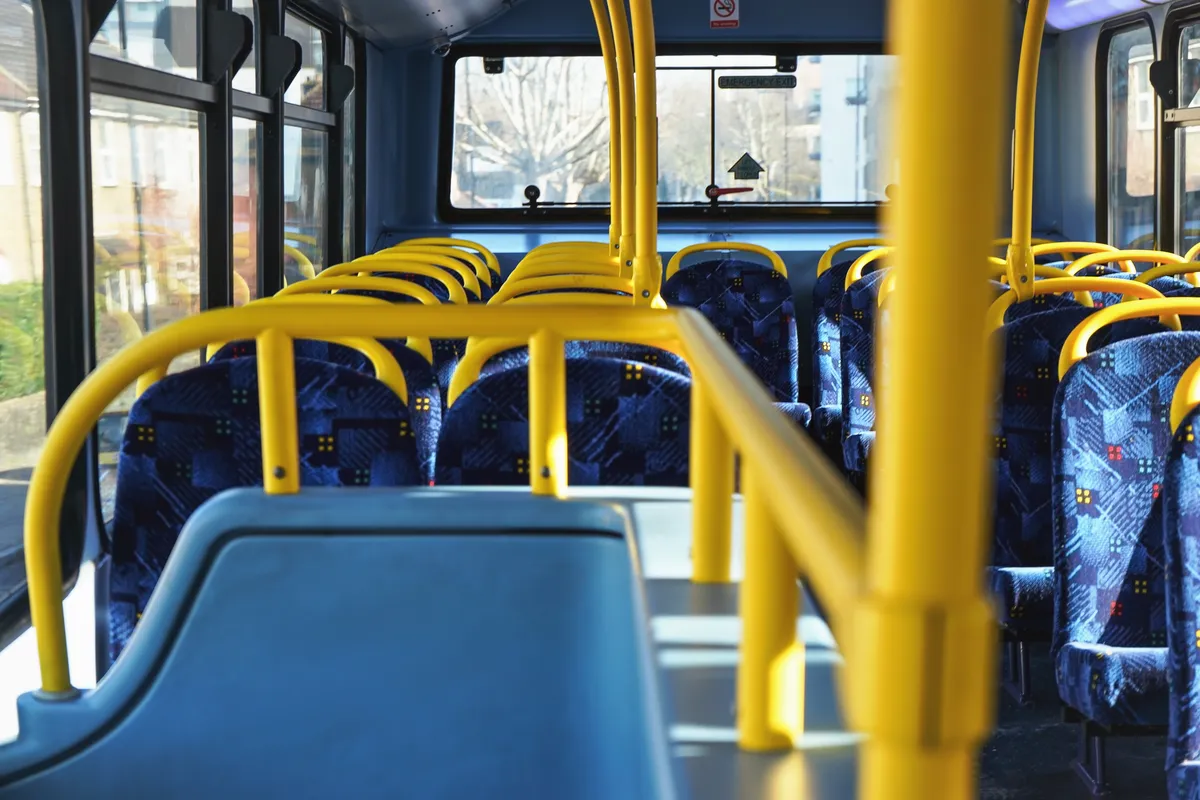 arafed view of a bus with blue seats and yellow railings