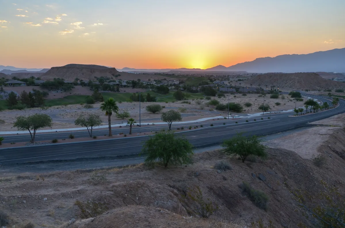 arafed view of a highway with a sunset in the background
