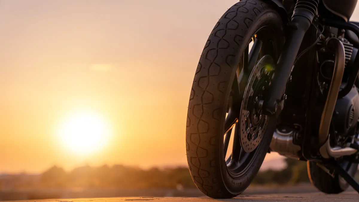 arafed view of a motorcycle parked on a road at sunset