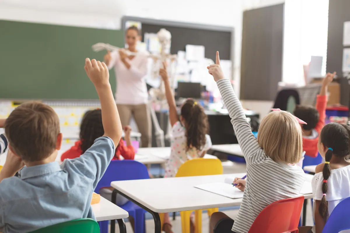  many children sitting at desks in a classroom