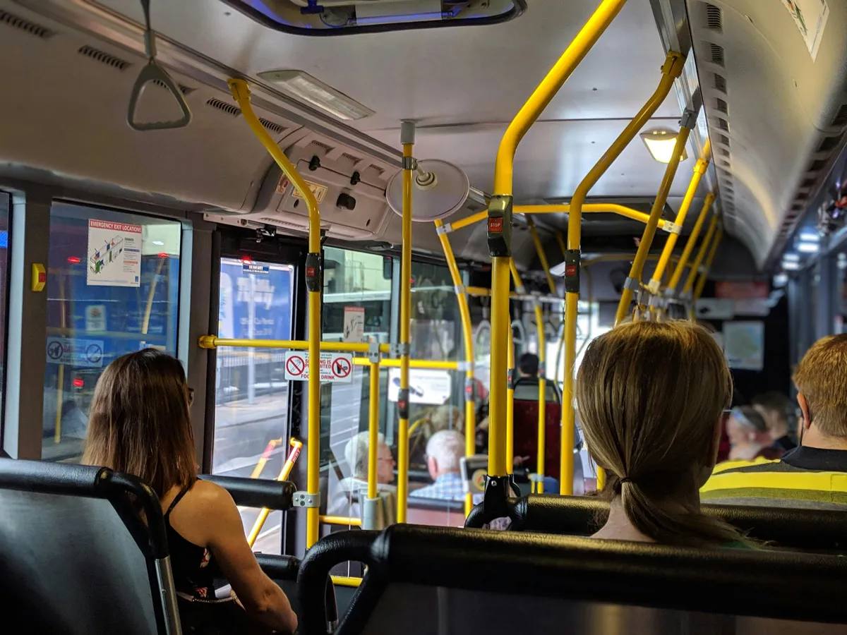 people sitting on a bus with their backs turned