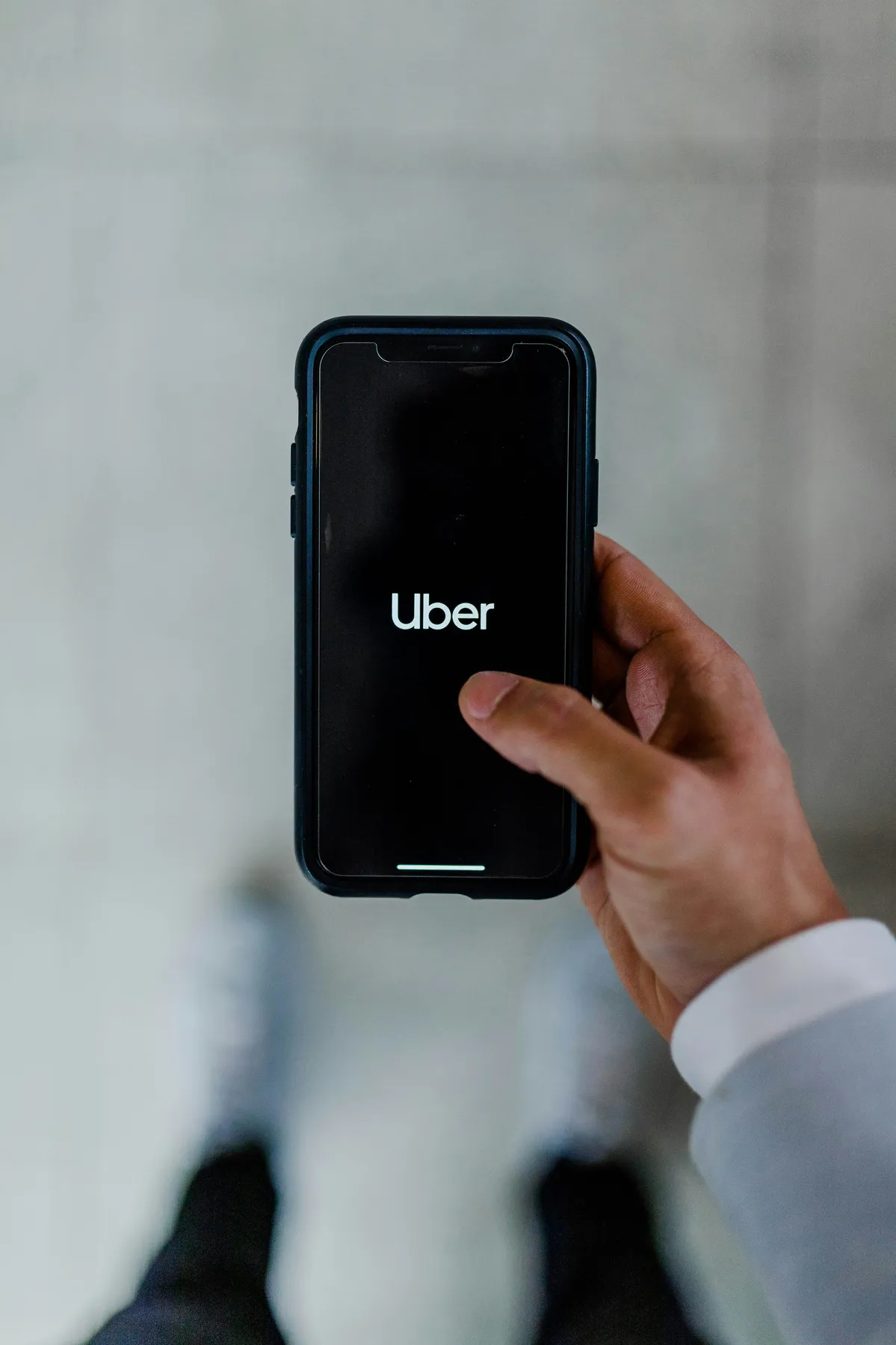 someone holding a cell phone with the uber logo on it