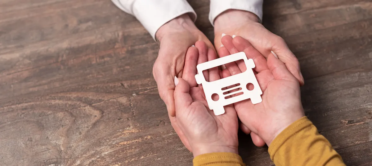 someone holding a paper model of a bus in their hands