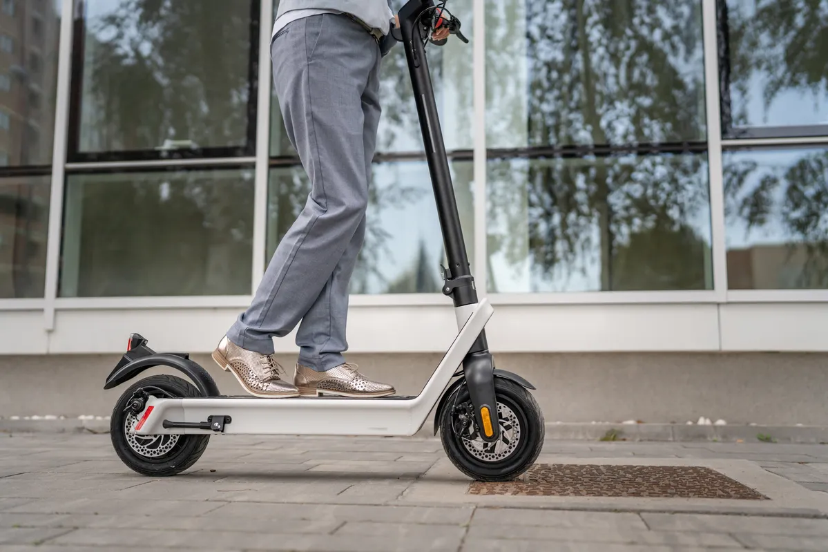 someone is riding a scooter on the sidewalk in front of a building