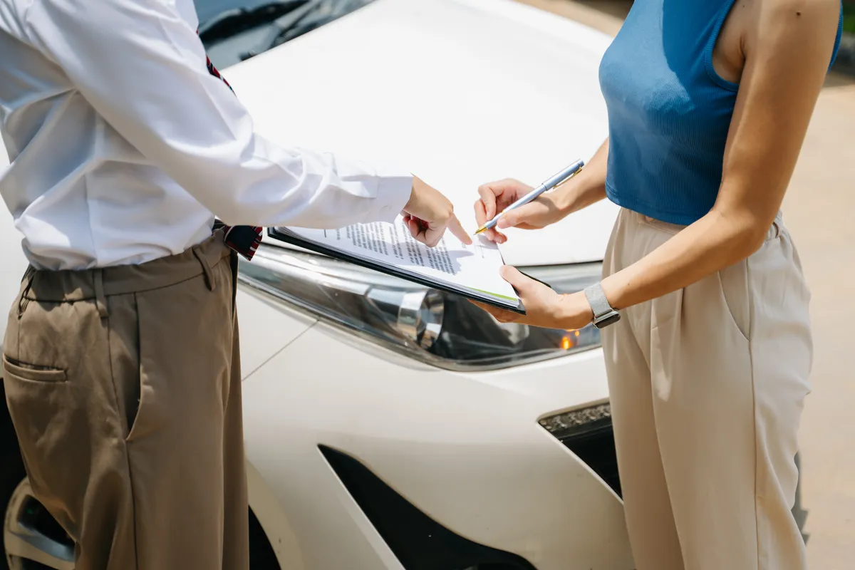  standing next to a car and talking to each other