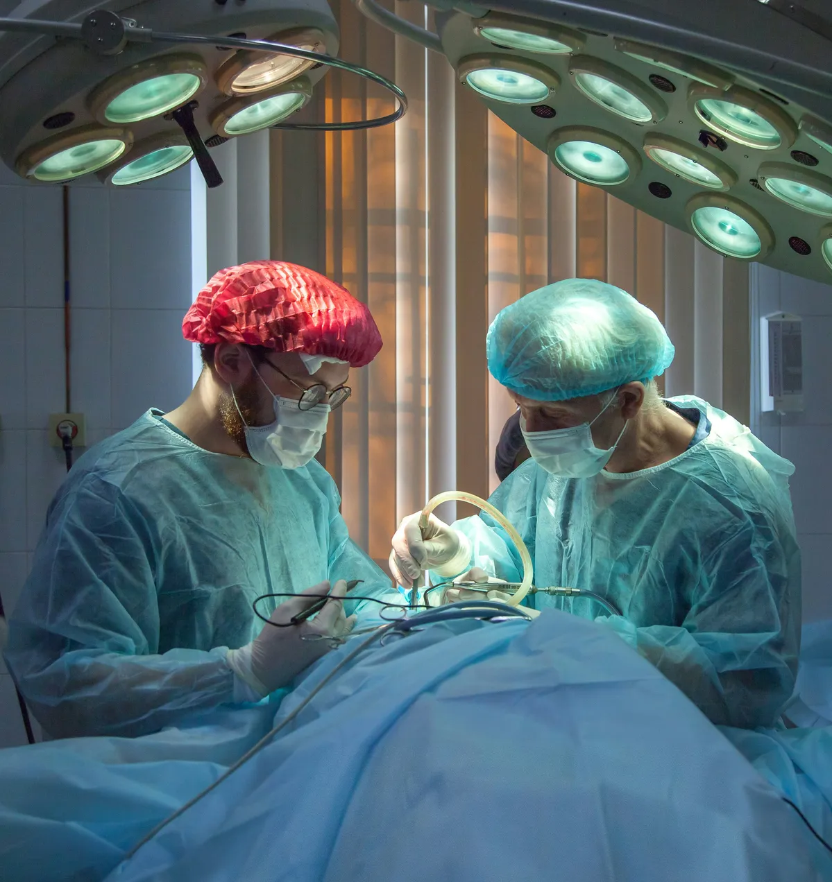 two surgeons are performing surgery in a hospital operating room