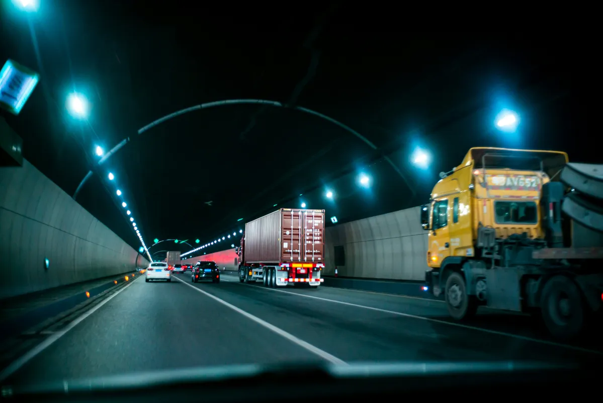  two trucks driving down the highway at night