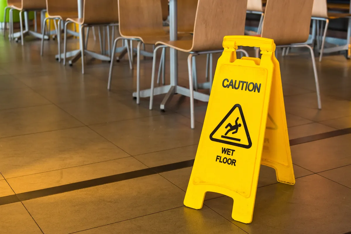 yellow caution sign sitting on the floor in a classroom